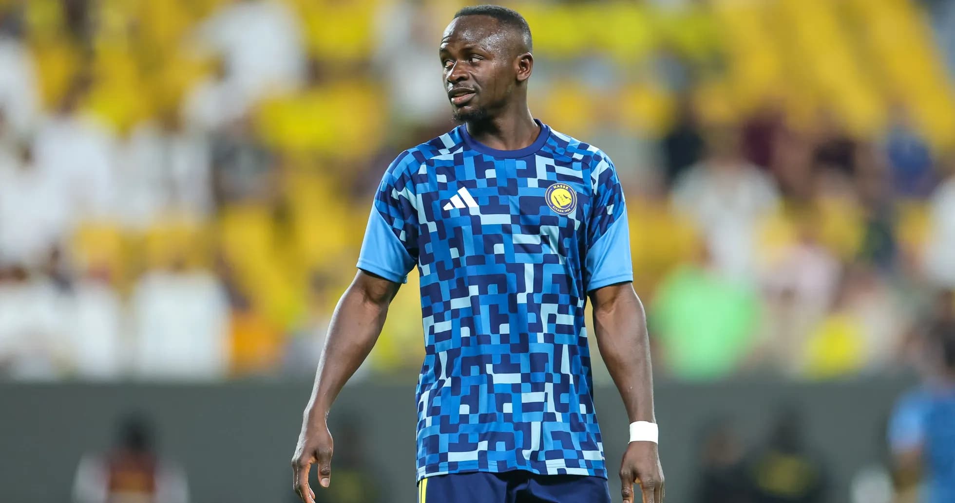 Jugador en calentamiento con camiseta azul en el estadio