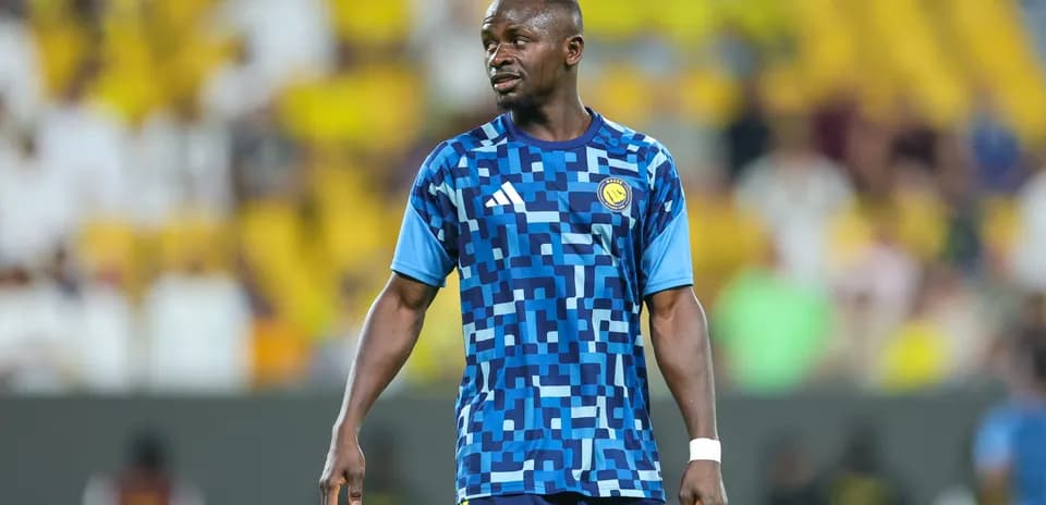 Jugador en calentamiento con camiseta azul en el estadio