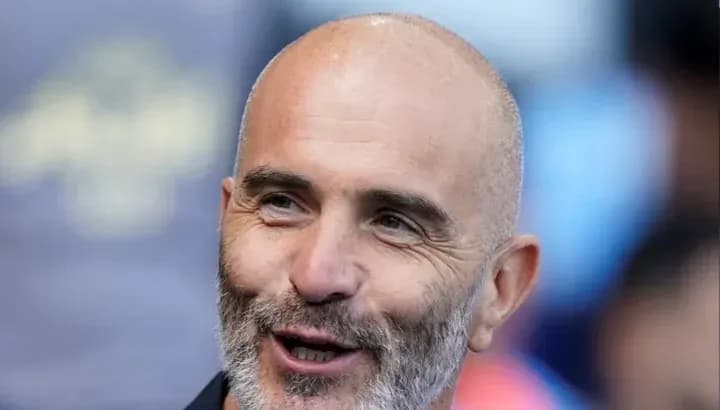 Hombre con barba sonriendo en un evento deportivo