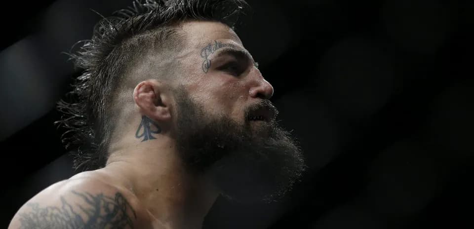 Luchador con barba y tatuajes en el rostro