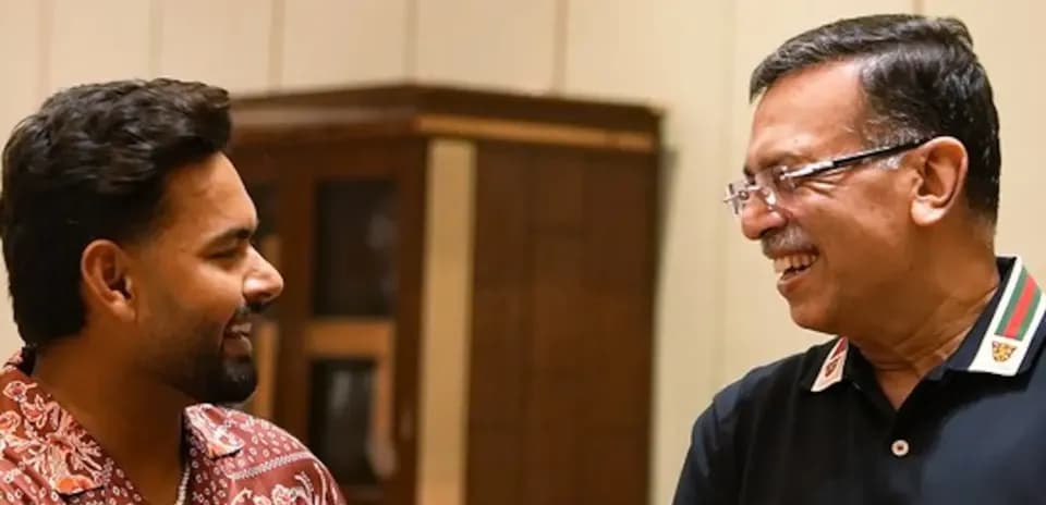 Dos hombres sonriendo y conversando en interior