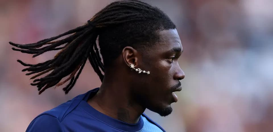 Jugador con trenzas y pendientes en el campo