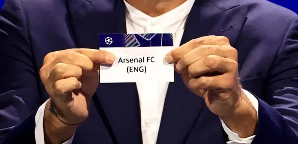Persona sosteniendo tarjeta de Arsenal FC en sorteo