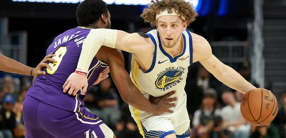 Jugador de los Warriors driblando mientras es defendido