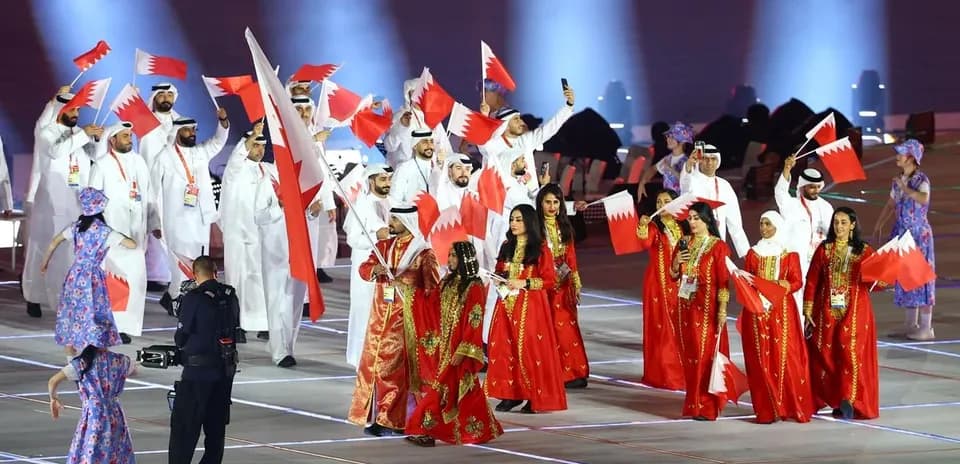 Delegación de Bahréin desfilando con banderas en evento