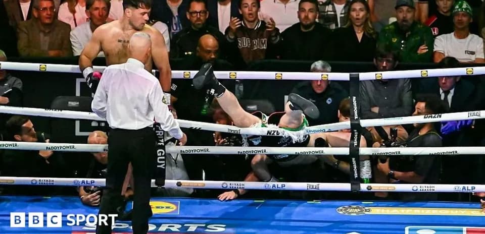 Boxer knocked out, lying outside the ring