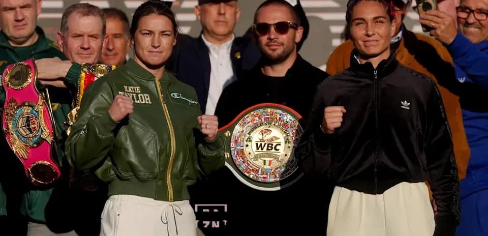 Katie Taylor y rival posando con cinturones de boxeo