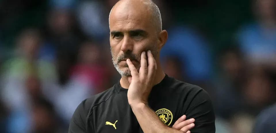 Entrenador observando el partido con expresión pensativa