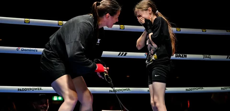 Boxeadora conversando con una niña en el ring