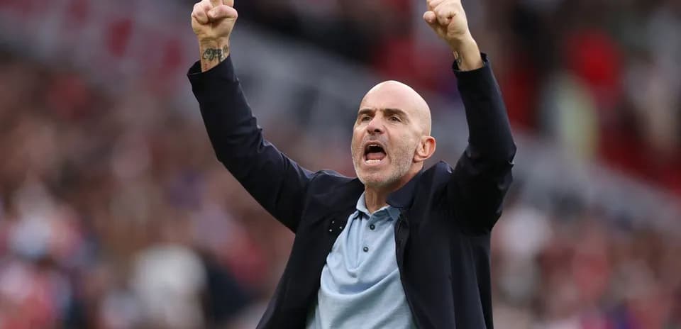 Entrenador celebrando con los brazos en alto