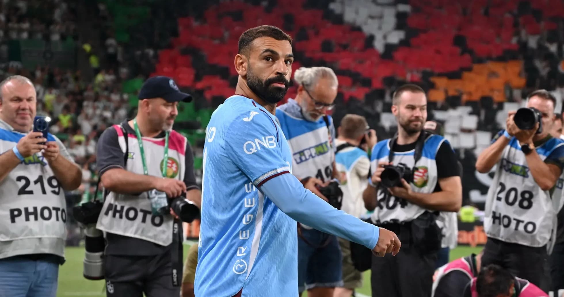 Jugador en uniforme mientras fotógrafos lo capturan