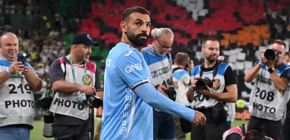 Jugador en uniforme mientras fotógrafos lo capturan