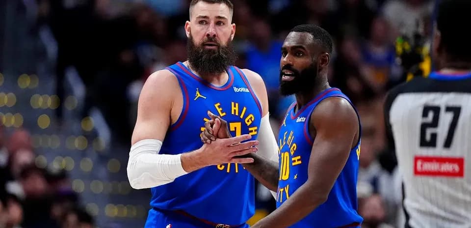 Jugadores de Denver Nuggets conversando en la cancha
