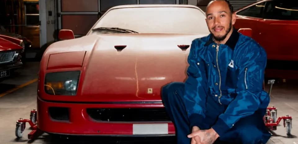 Hombre posando junto a un coche deportivo rojo