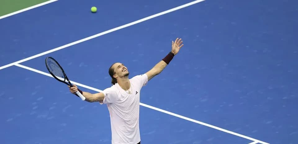 Jugador celebrando en la cancha de tenis azul