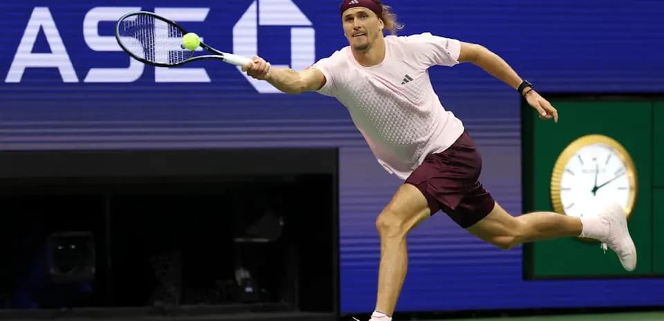 Jugador de tenis alcanzando una pelota en movimiento