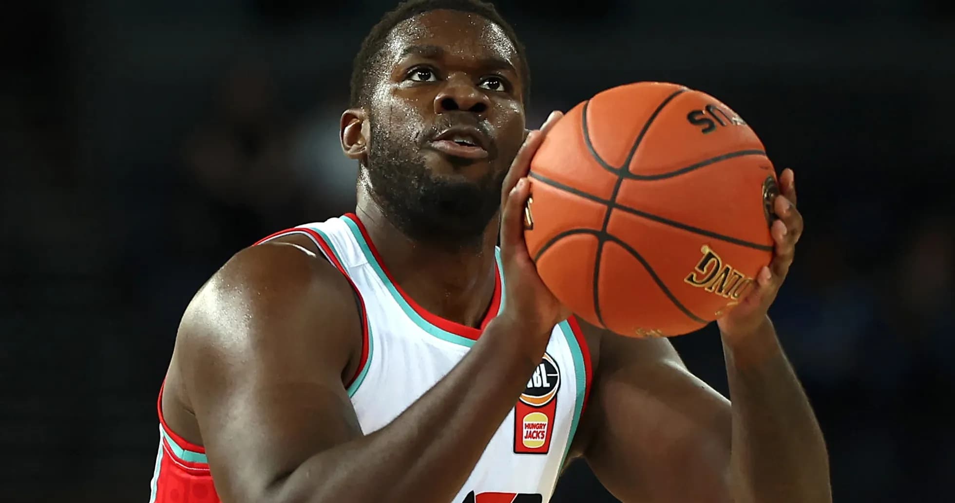 Jugador lanzando el balón durante un partido de baloncesto