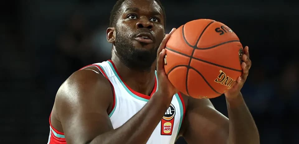 Jugador lanzando el balón durante un partido de baloncesto