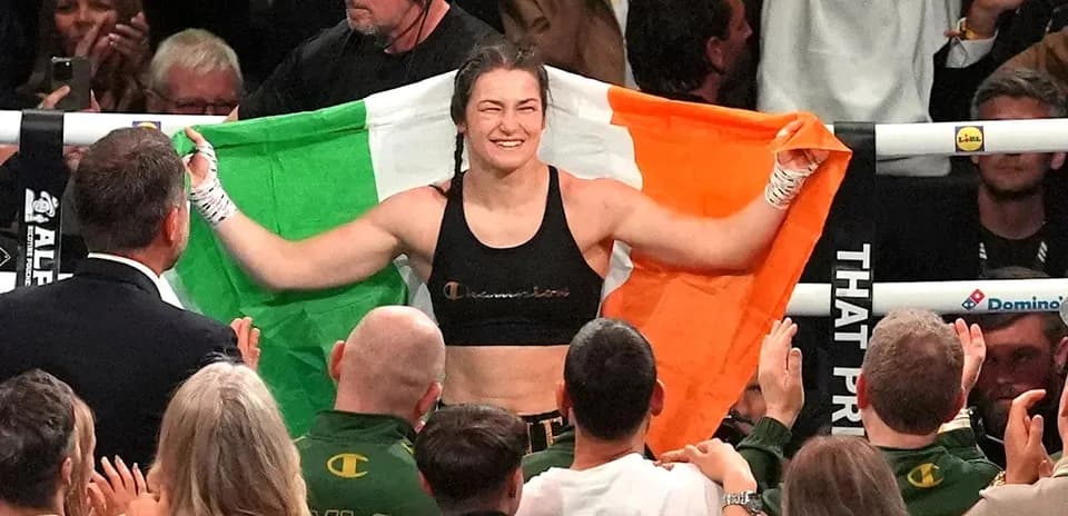 Boxeadora sosteniendo la bandera irlandesa en el ring