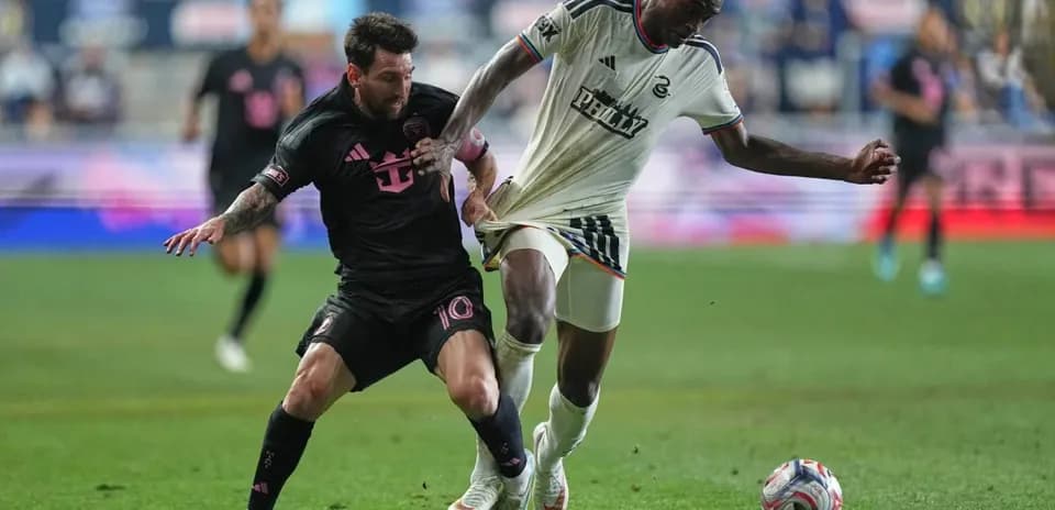 Lionel Messi battling for the ball against defender