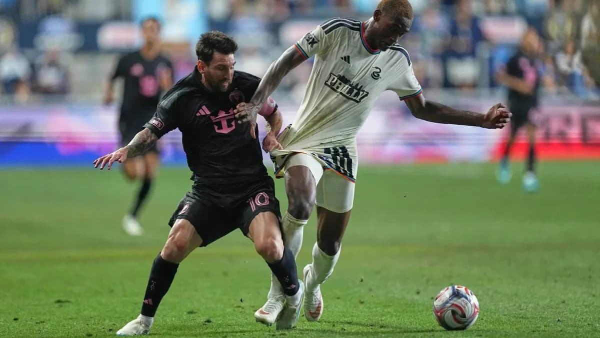 Lionel Messi battling for the ball against defender