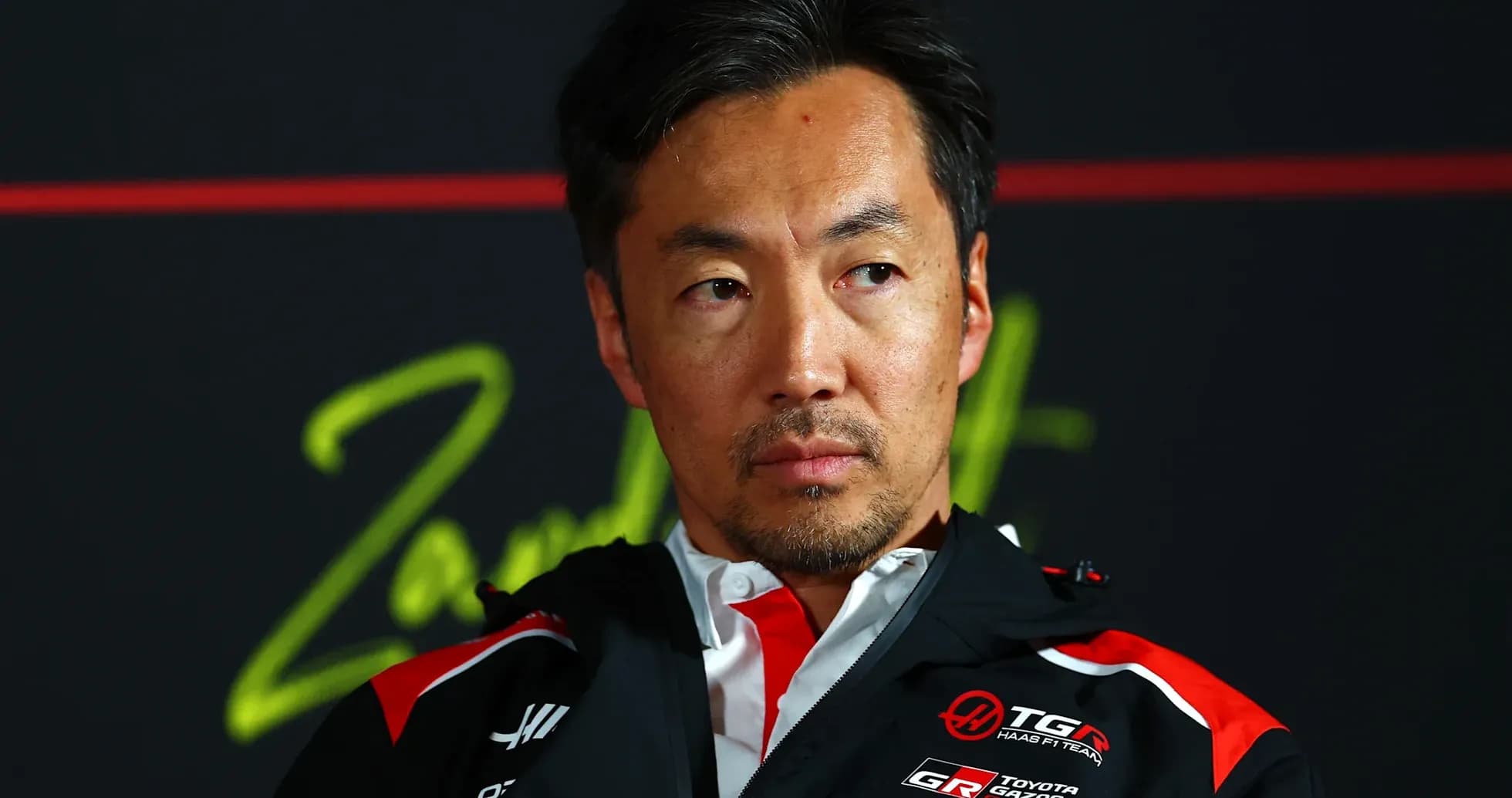 Persona en conferencia de prensa con chaqueta de equipo