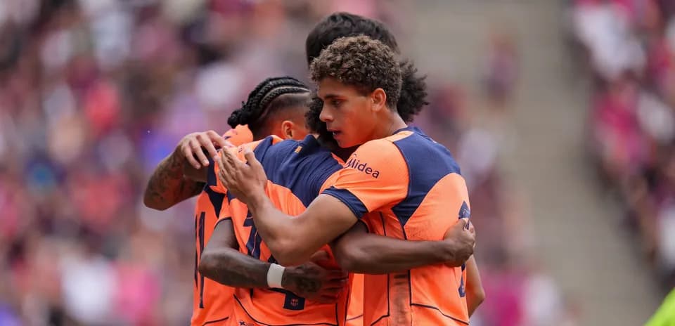 Jugadores abrazándose en celebración durante el partido