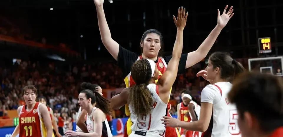 Jugadora bloqueando un tiro durante partido de baloncesto