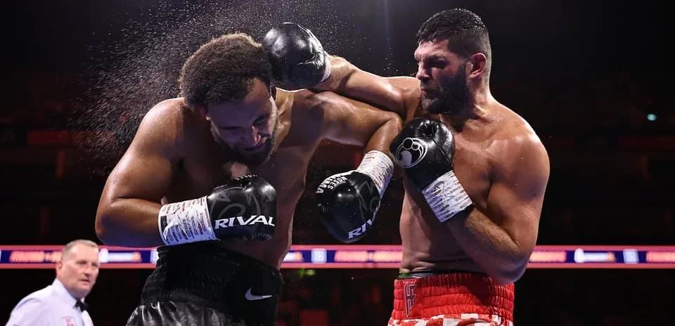 Boxeadores intercambiando golpes en el ring