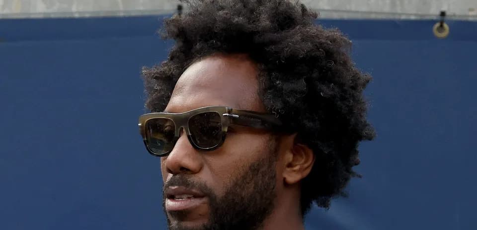 Hombre con gafas de sol y cabello rizado