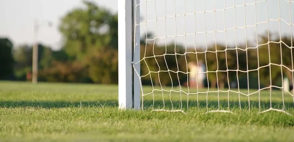 Poste de gol con red en campo de fútbol