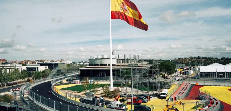 Circuito con bandera de España y vehículos en construcción