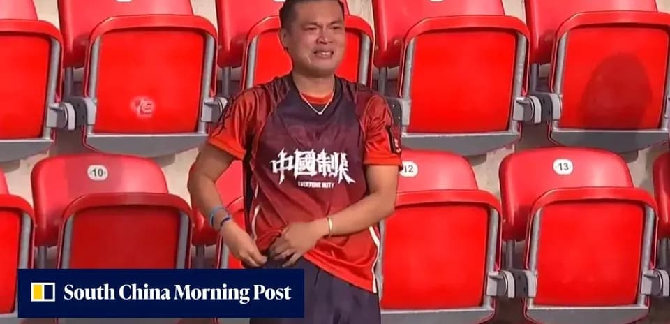A fan wearing an orange jersey in empty stadium