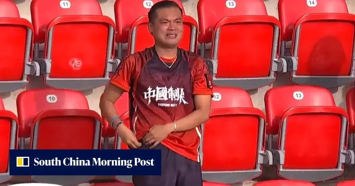 A fan wearing an orange jersey in empty stadium