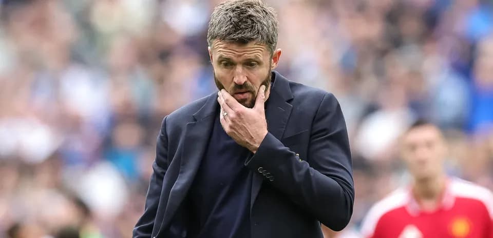 Entrenador pensativo durante un partido de fútbol