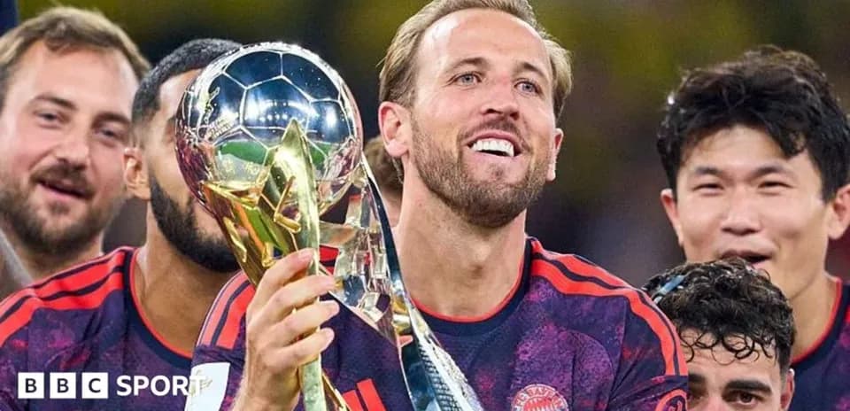 Jugador levantando trofeo con compañeros sonrientes