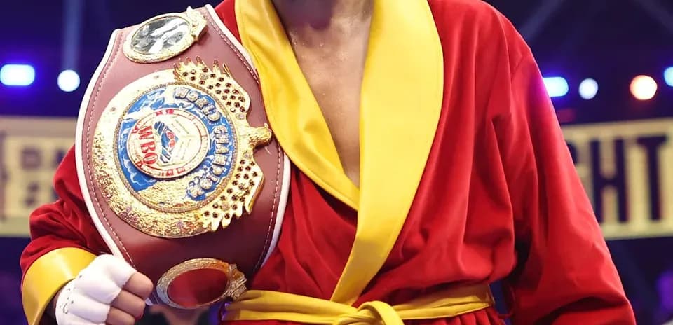 Boxeador sosteniendo cinturón en ring