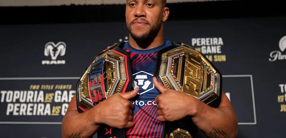 Luchador sosteniendo dos cinturones de campeonato