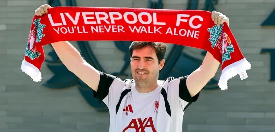 Jugador levantando bufanda de Liverpool FC