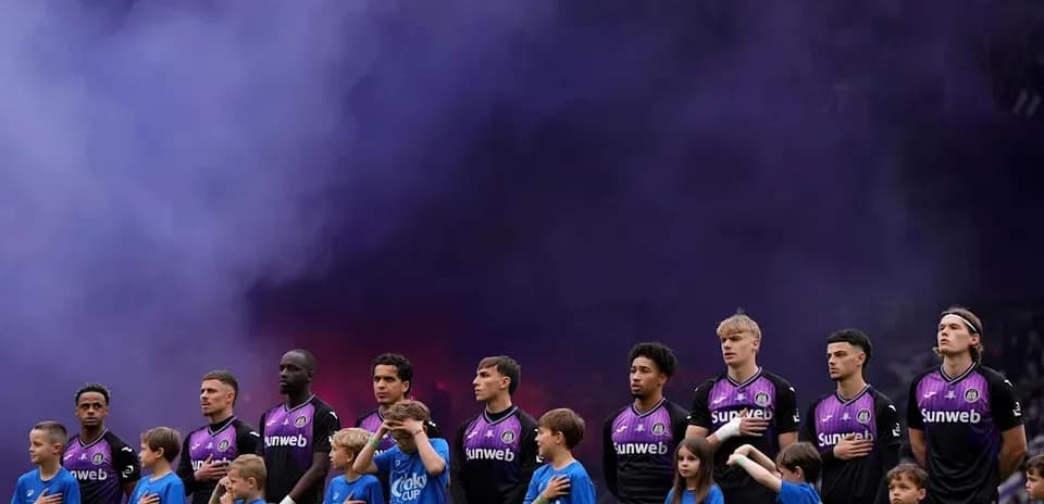 Jugadores alineados con niños antes del partido