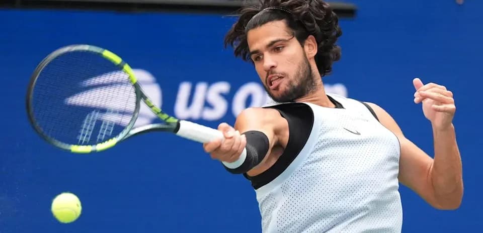 Jugador golpeando la pelota en un partido de tenis