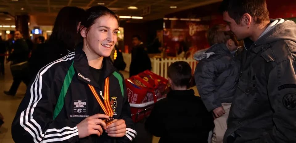 Atleta sonriente con medalla en aeropuerto