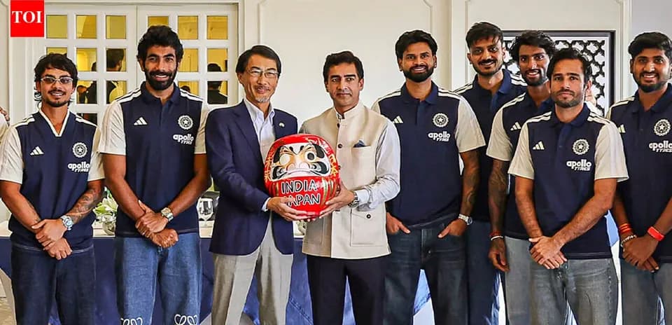 Equipo de cricket posando con figura de Daruma