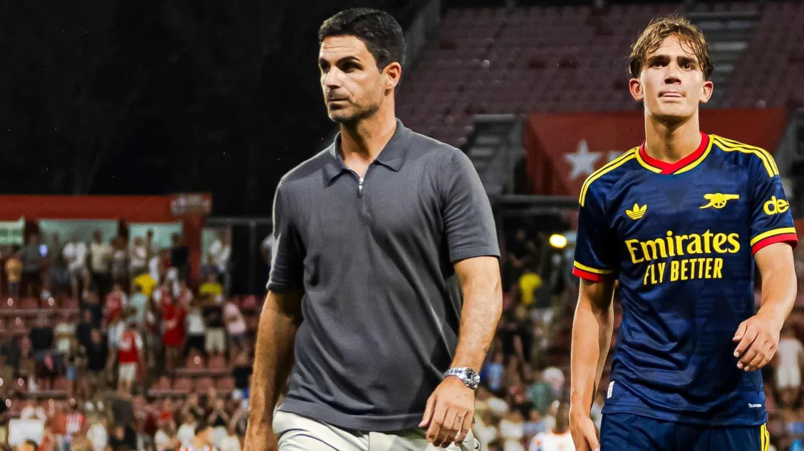 Entrenador y jugador saliendo del campo tras partido