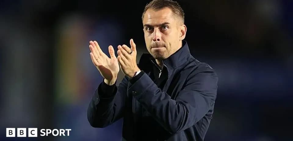Entrenador aplaudiendo en el banquillo durante partido