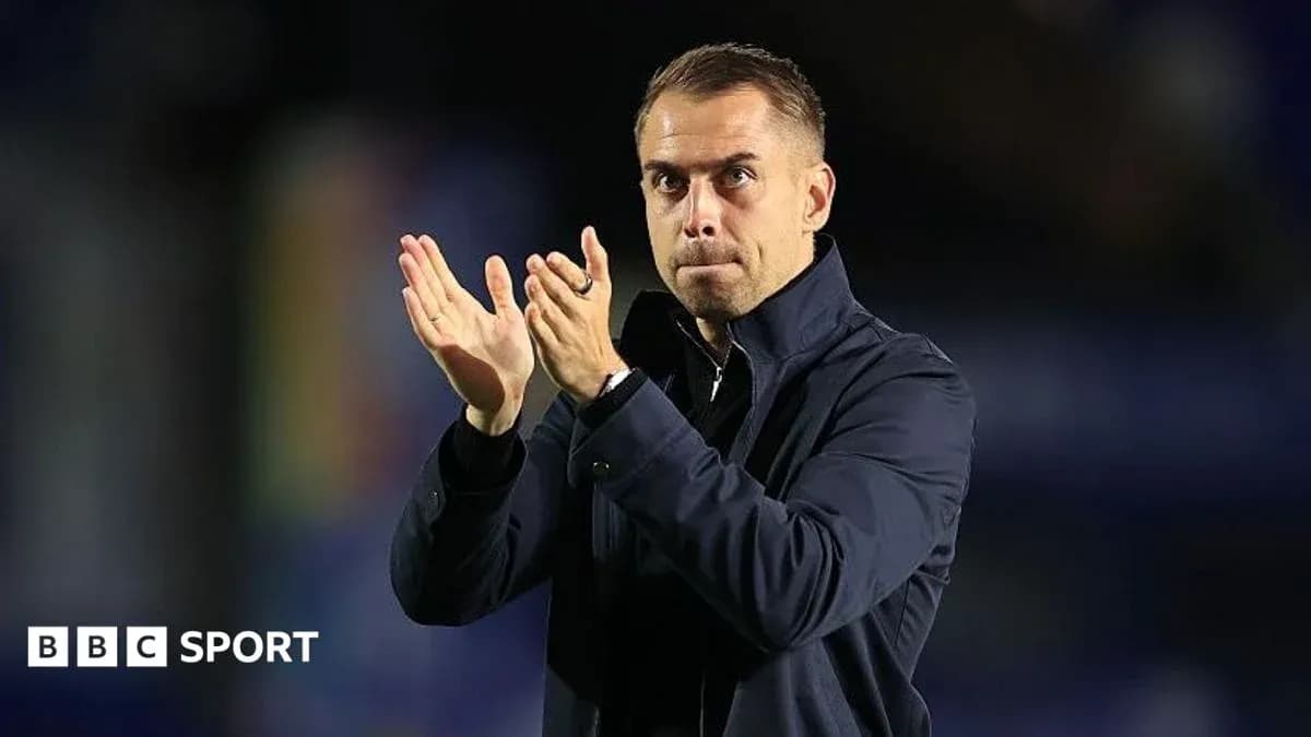 Entrenador aplaudiendo en el banquillo durante partido
