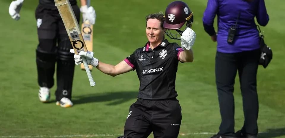 Jugador de cricket levantando su bate tras anotar