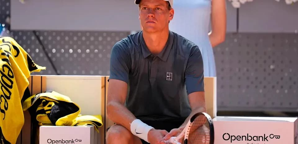 Jugador de tenis sentado en banco de descanso
