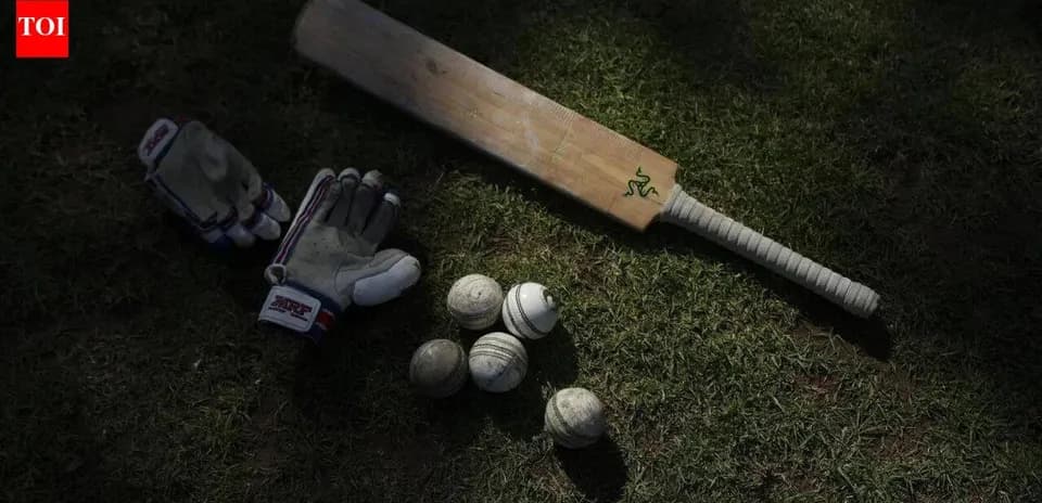 Bate de cricket y guantes sobre el césped