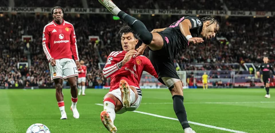 Jugador de Manchester United derribando a adversario en partido